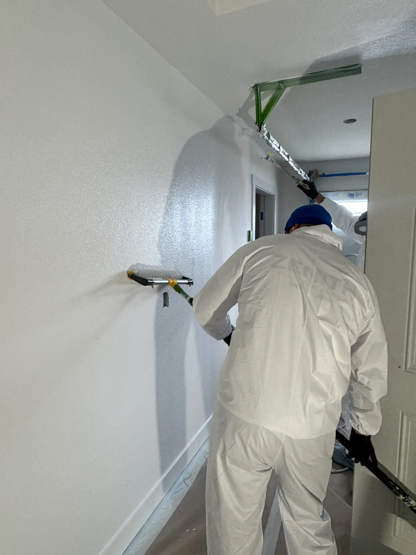 Zenith Paint and Finish crew applying fresh interior paint to hallway walls in a Powell WY home
