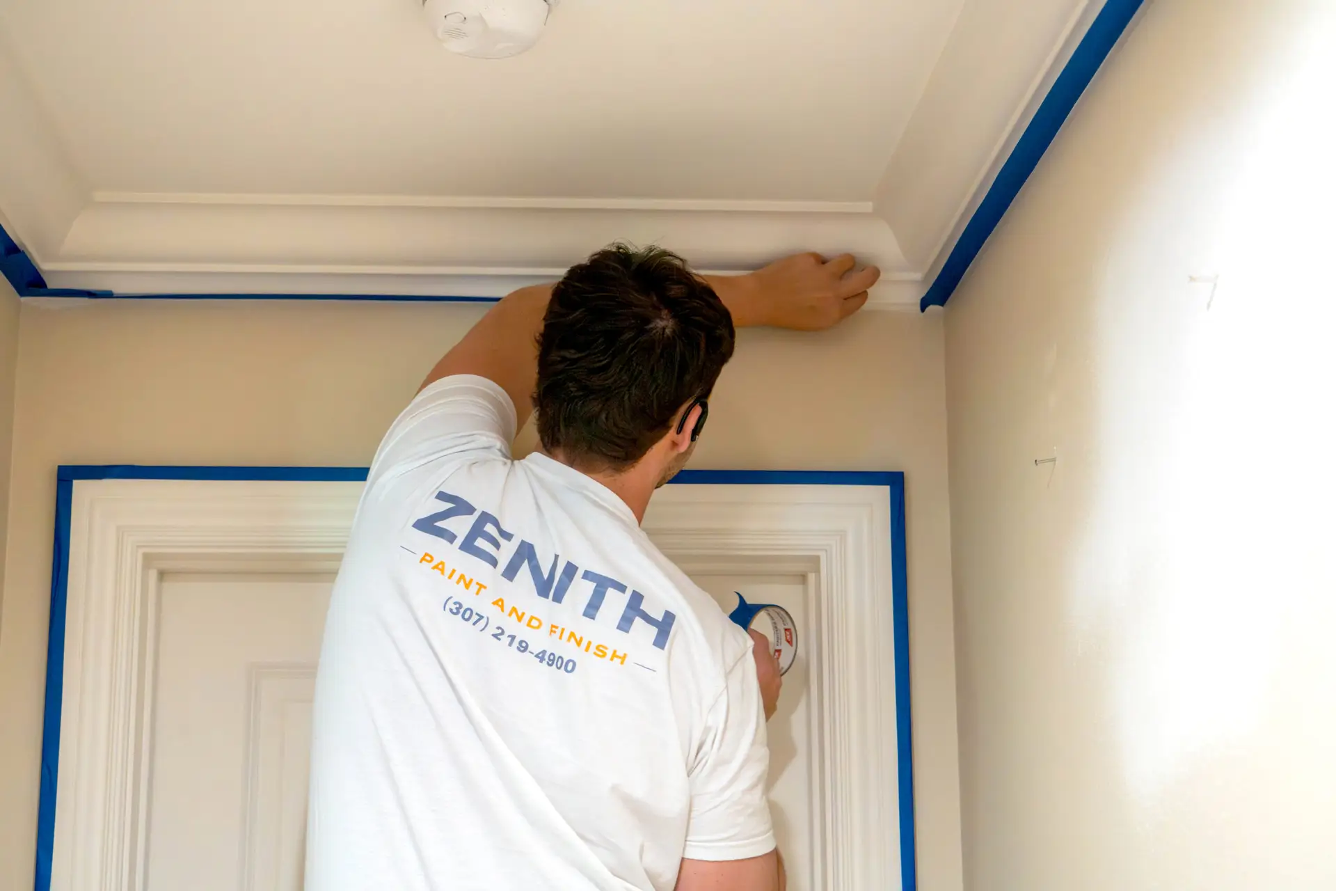A Zenith Paint and Finish painter checking trim for a smooth, flawless finish